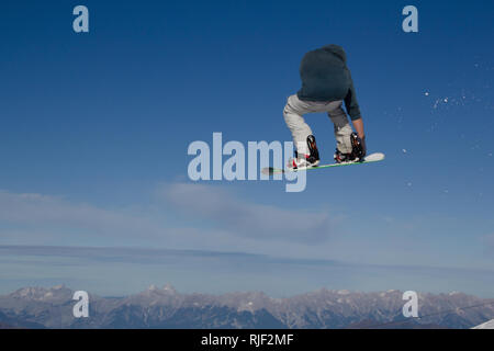 Snowboarder gets airborne after jumping over a kicker in the Kitzsteinhorn Funpark in Austria in the Alps in Europe Stock Photo