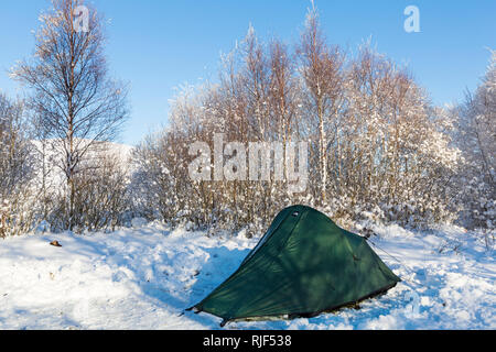 tent pitched in the snow in car parking space along the long road by Coupall Falls to Glen Etive at Rannoch Moor, Highlands, Scotland in Winter Stock Photo