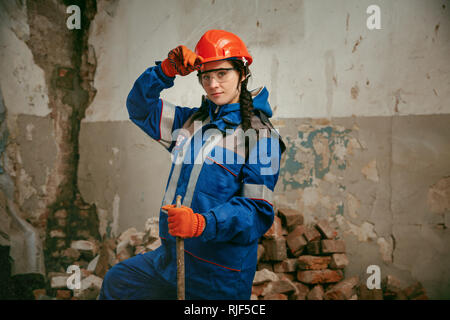 Destroying gender stereotypes. Woman wearing helmet using different male work tools. Gender equality. Girl working at flat remodeling. Building, repair and renovation. woman in the male profession Stock Photo
