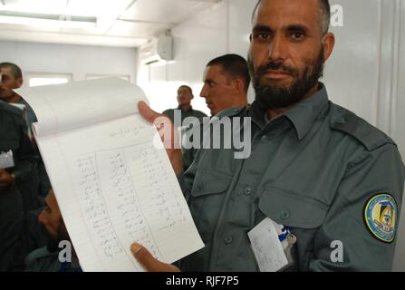 Kandahar Province, Afghanistan (July 10, 2010) – An Afghan National Police recruit shows off his handwritten work in a classroom at Recruit Training Center-Kandahar. The RTC-K currently has 349 recruits being trained to fill the ranks of the Afghan National Police. U.S. Navy Stock Photo