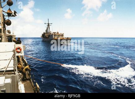 A view taken from onboard the US Navy (USN) Cyclone Class Coastal Defense Ship, USS HURRICANE (PC 3), showing as a trailing refueling line being extended from the USN Oliver Hazard Perry Class: Guided Missile Frigate, USS JOHN H. SIDES (FFG 14), as the two ships conduct Replenishment At Sea (RAS) operations while underway in the Pacific Ocean participating in a Coordination Afloat Readiness and Training (CARAT) Exercise, while executing the first trans-Pacific cruise of a Patrol Forces boat. Stock Photo