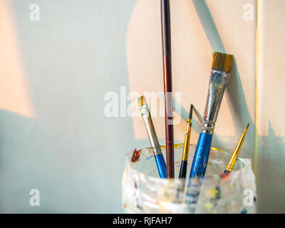 Paint brushes in old plastic cup with copy space. Stock Photo