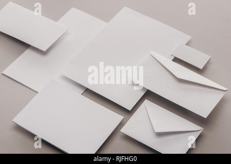 flat lay with blank white papers and envelopes on grey background Stock Photo