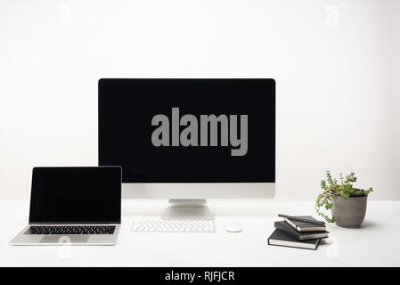 workplace with notebooks, desktop computer and laptop with copy space isolated on white Stock Photo