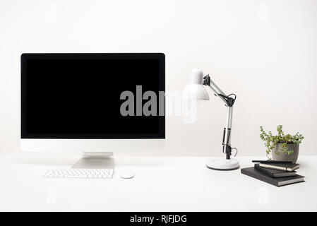 workplace with lamp, plants, notebooks and desktop computer with copy space isolated on white Stock Photo