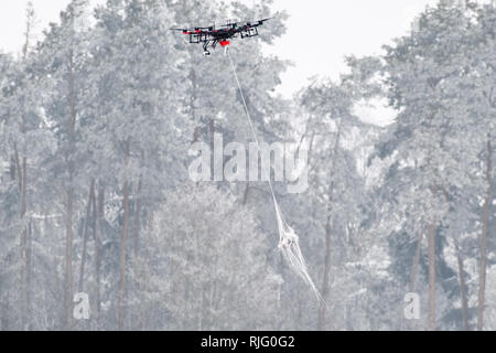 Manching, Germany. 06th Feb, 2019. A fighter drone of the type AirRobot AR200 transports on a presentation day of the German Federal Armed Forces to track down and fend off drones a commercial small drone, which it caught before with a dropped net. During a presentation day at the Manching airfield near Ingolstadt, it will be demonstrated how the flying objects can be detected, forced to an emergency landing with interference radiation or taken down from the sky with an interceptor drone. Credit: Matthias Balk/dpa/Alamy Live News Stock Photo