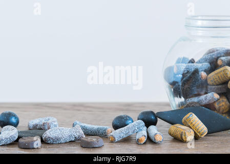 Close-up of assorted salmiakki on table and in candy jar Stock Photo