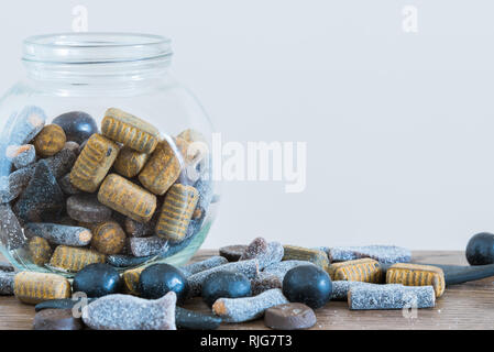 Close-up assorted salmiakki in candy jar and on table Stock Photo