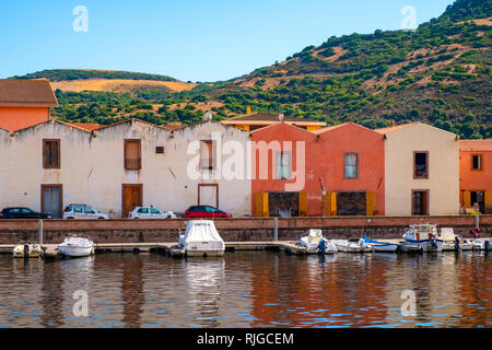 Bosa, Sardinia / Italy - 2018/08/13: Panoramic view of the old town quarter of Bosa by the Temo river embankment with colorful tenement houses and boa Stock Photo