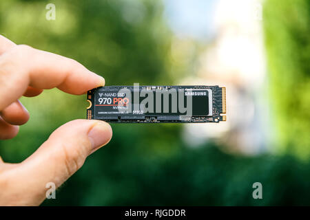 PARIS, FRANCE - JUL 27, 2018: Man hand holding new Samsung 870 Pro NVME PCIE SSD hard drive disk front face with high read and write speed Samsung 870 Pro Stock Photo