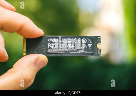 PARIS, FRANCE - JUL 27, 2018: Man hand holding new Samsung 870 Pro NVME PCIE SSD hard drive disk with high read and write speed Samsung 870 Pro rear side with standards logo Stock Photo