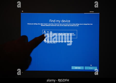 LONDON, UNITED KINGDOM - JUL 23, 2018: Hand interacting on digital touchscreen after Microsoft Windows Update installation - find my device yes button Stock Photo