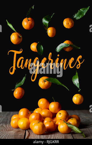 organic tangerines with green leaves isolated on black Stock Photo
