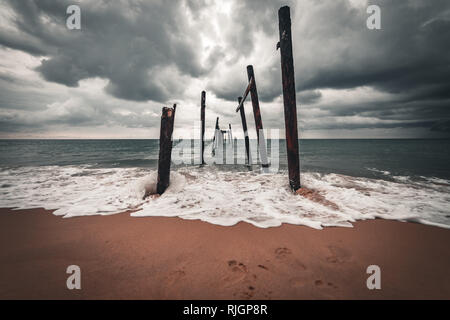 A ruined bridge on the ocean shore near the Aleenta Holiday Resort, Phuket, Thailand Stock Photo