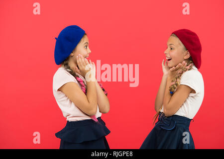 Surprised girls wear formal uniform red background. International exchange school program. Education abroad. Apply form enter international school. French language school. School fashion concept. Stock Photo