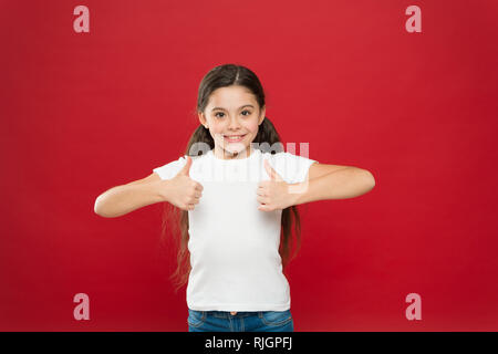 That is right. Little girl excited smiling face. Kid happy cute face feels excited red background. Exciting moments. Excitement emotion. Sincere excitement. Kid girl long hair wear casual clothes. Stock Photo