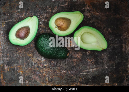 Cut avocados on a dark rustic background, horizontal Stock Photo