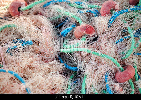Fishing net with ropes and floats is drying on the pier, close-up