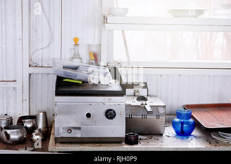 Industrial kitchenware over the counter of an abandoned and ruined kitchen that ran out of business. Stock Photo
