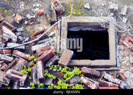 Pile of old rubble red bricks of a demolished building and a hole in a construction site. Top down view. Stock Photo