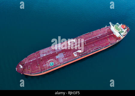 Aerial drone view of red empty cargo ship in the ocean