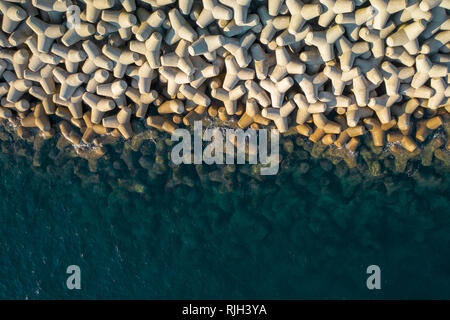 Breakwaters protection near sailboat port, embankment on foreground Stock Photo