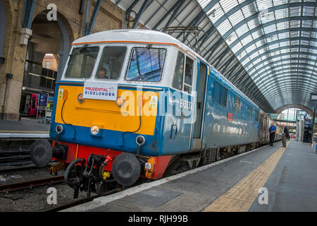 A class 86 electric locomotive named 'Les Ross' waiting at a platform in Kings Cross railway station, London.