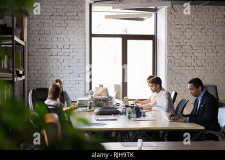 Diverse employees busy working in shared office  Stock Photo