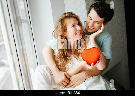 Couple in love watches a gift heart box on Valentine's day. Stock Photo