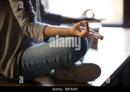 Close up of female meditating on table with mudra hands