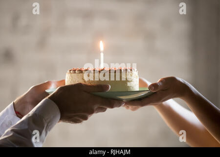 Close up of employee presenting cream pie with candle  Stock Photo