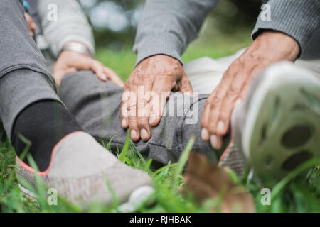 senior's hand giving massage on leg Stock Photo