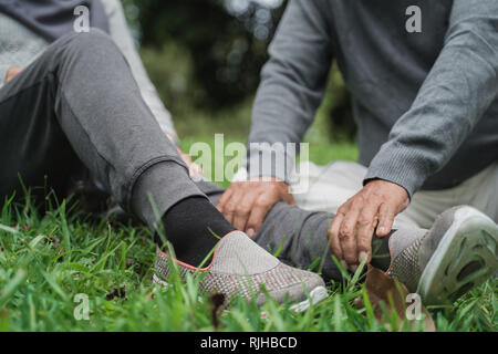 senior's hand giving massage on leg Stock Photo