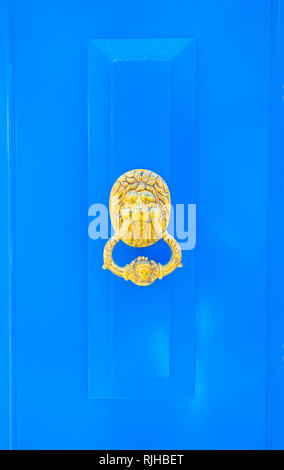 blue wooden door with lion´s head and door knocker Stock Photo