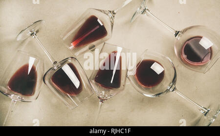 Flat-lay of red wine in glasses over grey concrete background Stock Photo
