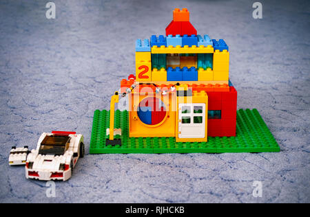 Tambov, Russian Federation - January 21, 2015 Custom made Lego Duplo house with two cars near on blue floor. Stock Photo