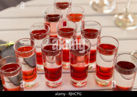 Variation of hard alcoholic shots served on on white table, catering. Stock Photo