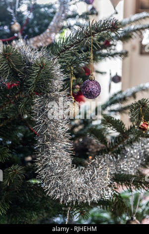 Silver tinsel and baubles on Christmas tree Stock Photo