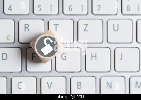 cube with an open lock symbol on a keyboard Stock Photo