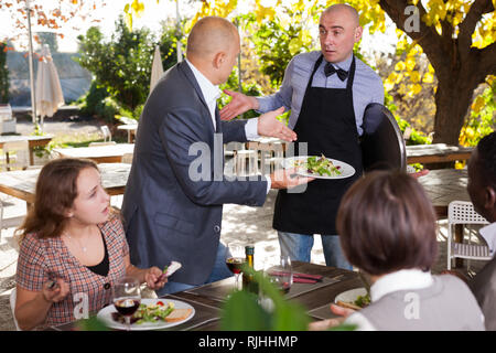 Restaurant guests complain about the food to the waiter Stock Photo