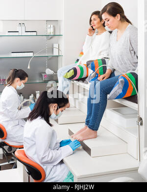 young women getting pedicure by professional in modern beauty salon Stock Photo