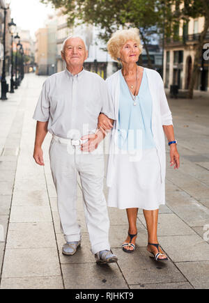 Smiling senior man and woman on vacation roaming around foreign city Stock Photo