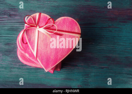 Pile of heart shaped gift boxes on blue wooden background Stock Photo