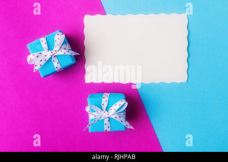 Two gift boxes and blank card over pink blue background. Valentines day concept Stock Photo