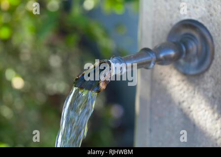 Closeup of water running from outdoor wall faucet Stock Photo