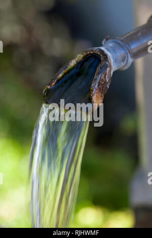 Closeup of water running from outdoor wall faucet Stock Photo