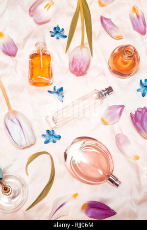 Perfume bottles, tulips and hyacinth on silk