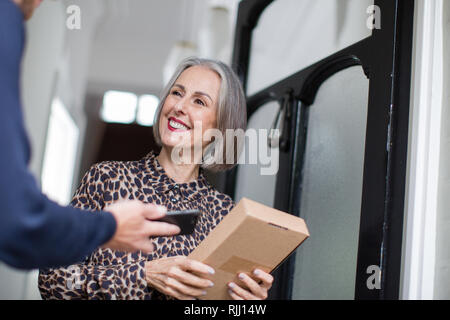 Mature woman receiving a home delivery Stock Photo