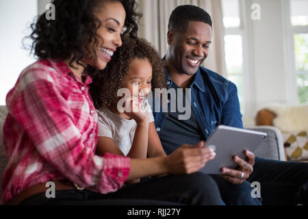 African American family watching video on digital tablet at home Stock Photo