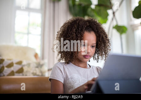 African American girl using digital tablet for homework Stock Photo
